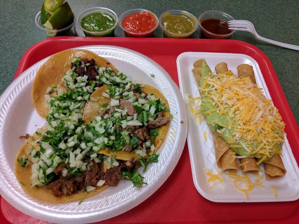 Menu board with tacos, burritos, and breakfast options.